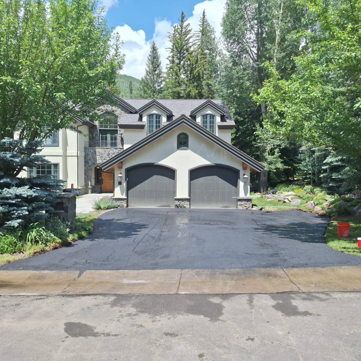 New asphalt at a two bay garage, graded so the water runs off instead of sitting