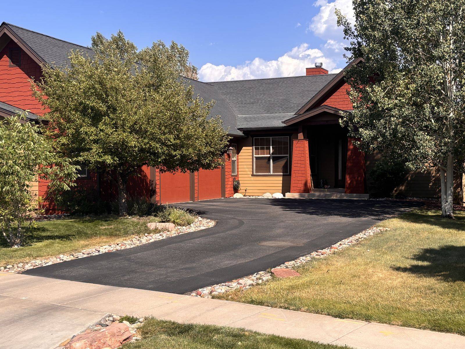 A freshly sealed asphalt driveway curving up to a home in Gypsum, Colorado